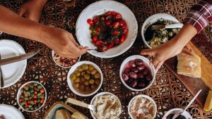 An appetizing spread of Mediterranean dishes enjoyed by friends at a vibrant communal table.